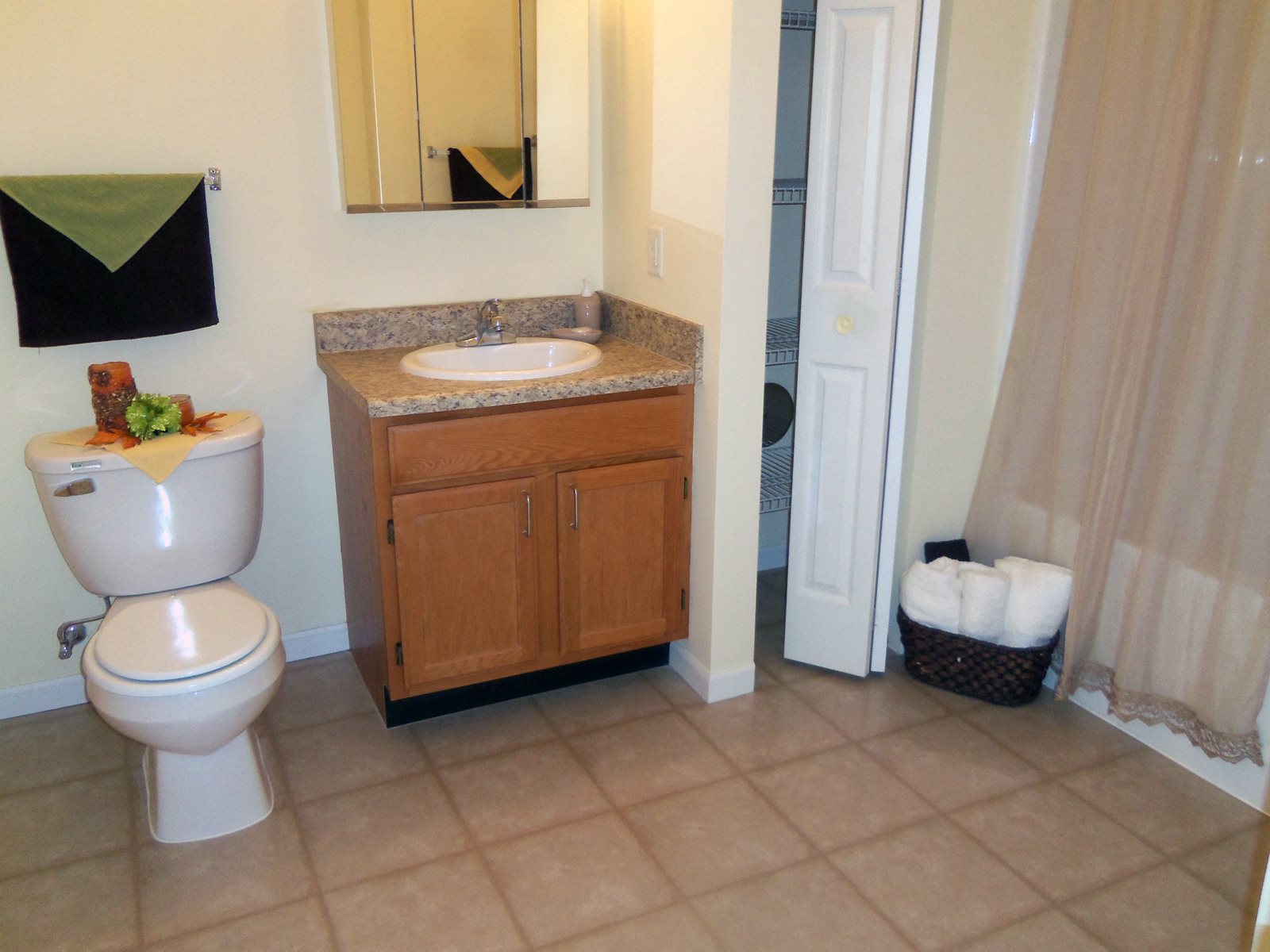 Bathroom, tile flooring, solid surface countertops, toilet and sink